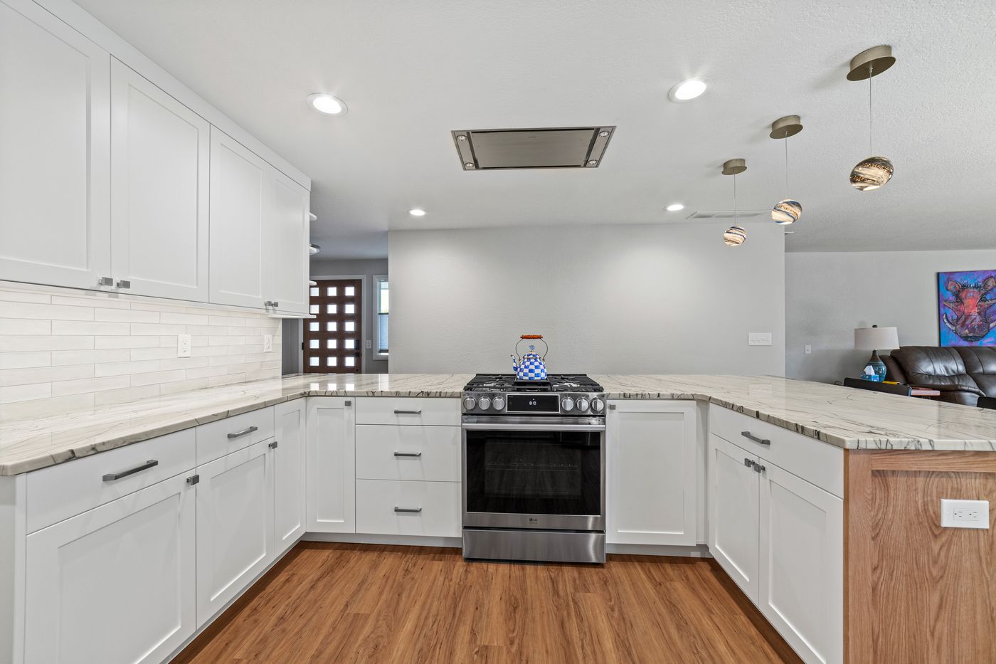 Wood-look plank flooring running through a white shaker kitchen